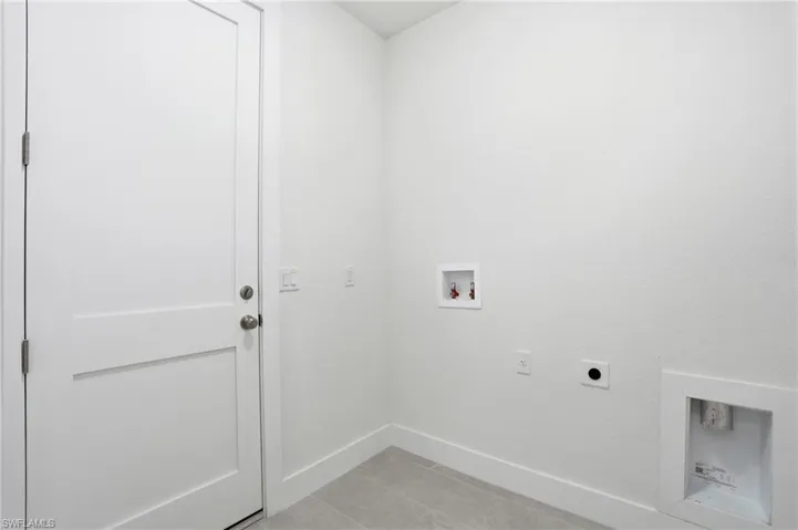 Laundry room with washer hookup, hookup for an electric dryer, and light tile patterned floors