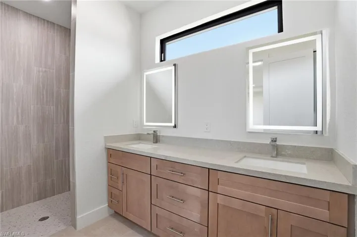 Master Bathroom featuring double vanity and a walk in shower