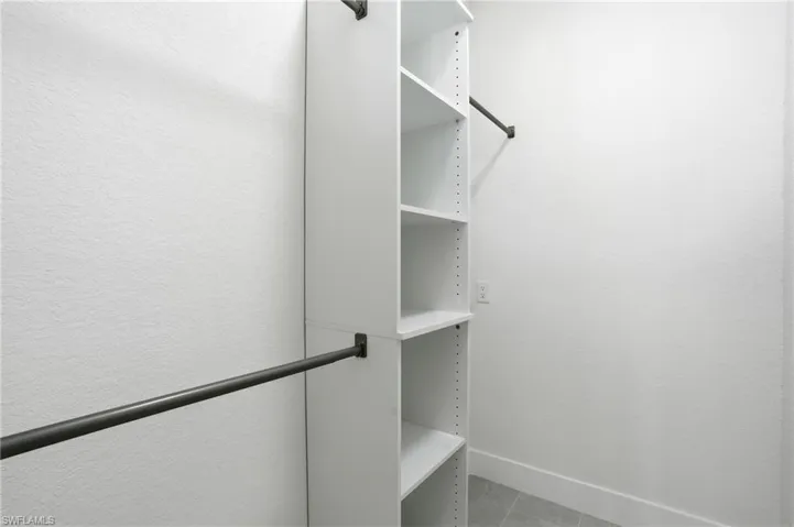 Walk in closet with light tile patterned floors