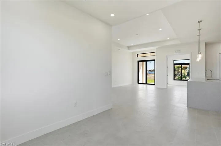 Dining room with recessed lighting, a tray ceiling, and light floors