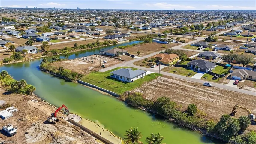 Aerial view of property and surrounding area with a large body of water and nearby suburban area