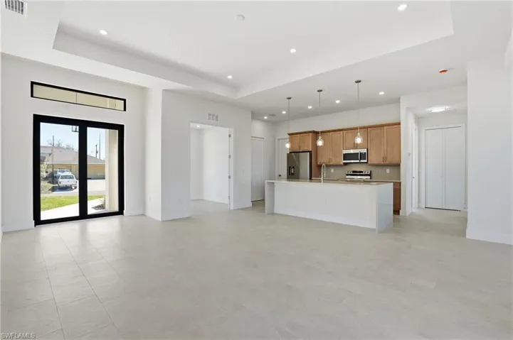 Unfurnished living room with a raised ceiling and recessed lighting