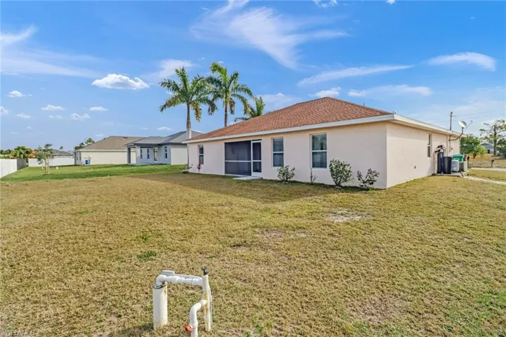 Rear view of house featuring a lawn