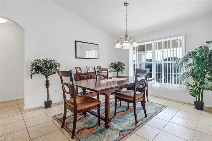 Tiled dining area with vaulted ceiling and a chandelier