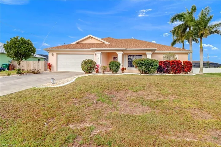 Single story home with a garage and a front yard