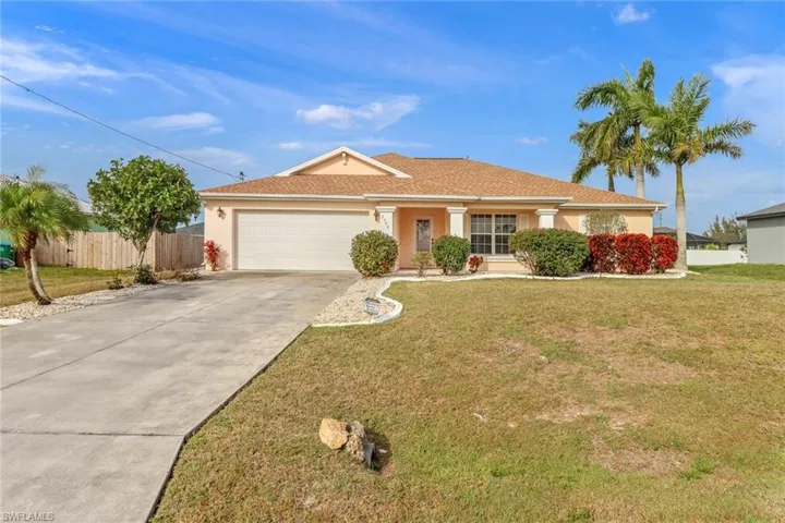 Single story home featuring a garage and a front yard