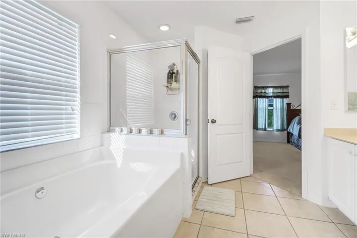 Bathroom with vanity, independent shower and bath, and tile patterned floors