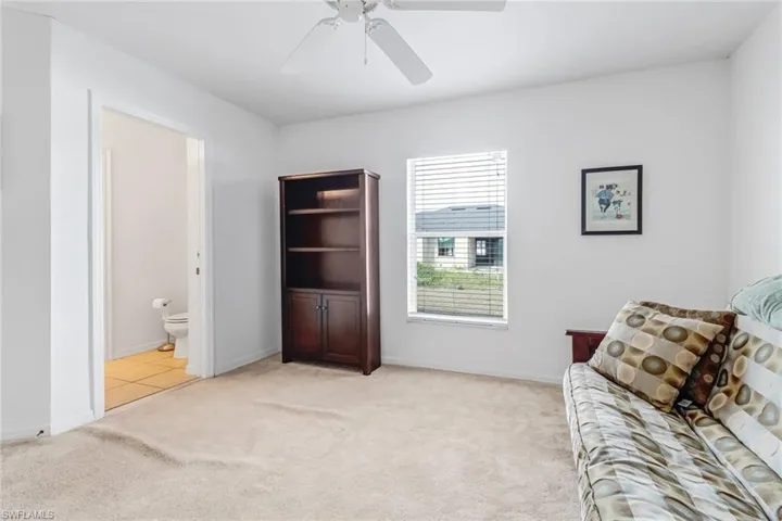 Living area with ceiling fan and light carpet