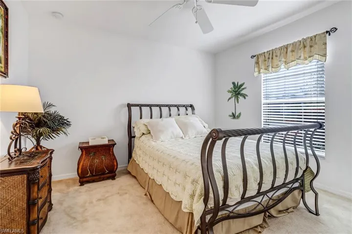 Carpeted bedroom featuring ceiling fan