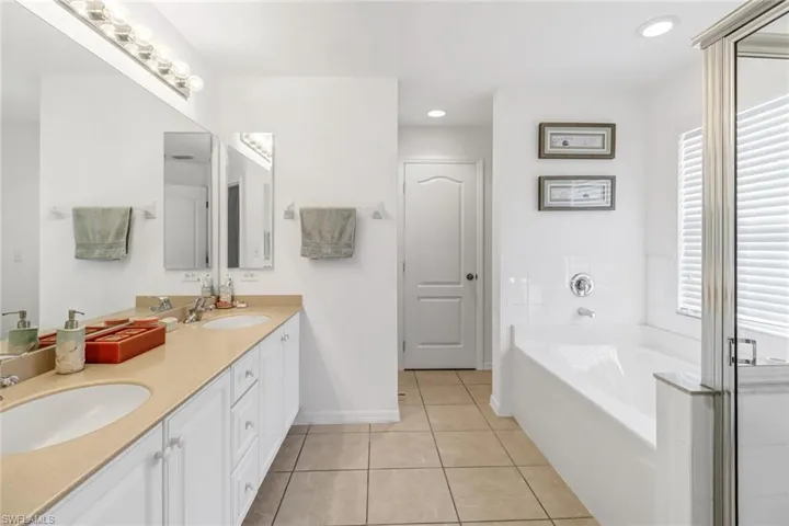 Bathroom with vanity, tile patterned floors, and a washtub
