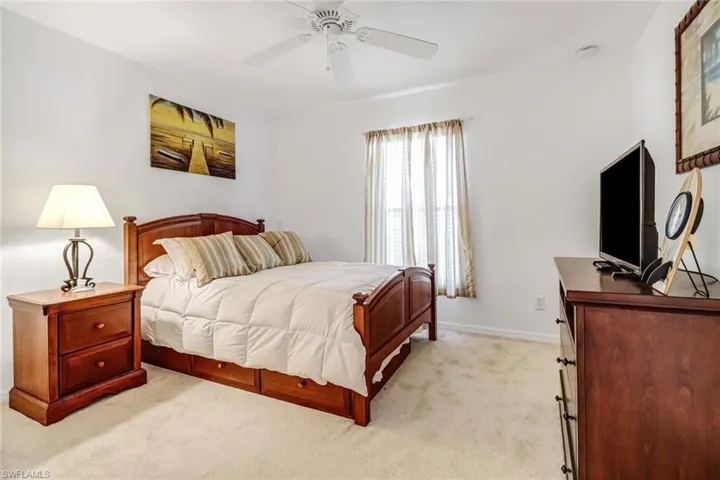 Carpeted bedroom featuring ceiling fan