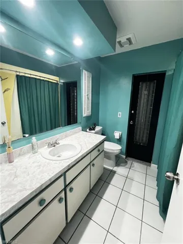 Bathroom featuring a shower with curtain, vanity, and light tile patterned floors