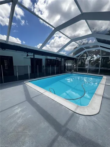 Swimming pool with a lanai, a sunroom, and a patio area