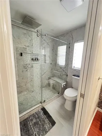 Bathroom with toilet and a marble finish shower