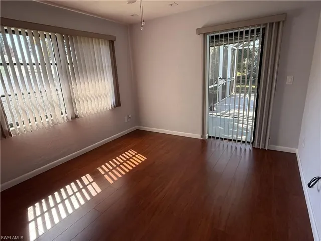 Unfurnished room with dark wood-type flooring and baseboards