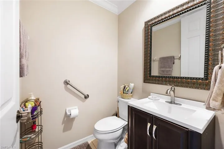 Half bath featuring vanity and crown molding