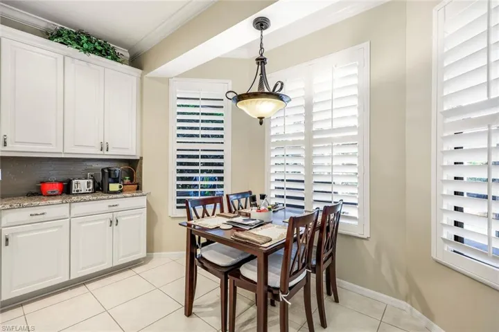 Dining space featuring crown molding and light tile patterned floors