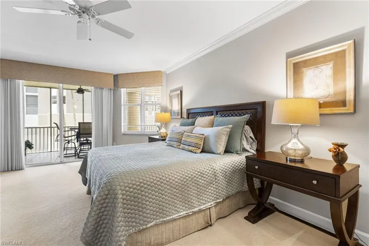 Your primary bedroom is generously proportioned, offering an oversized layout designed for both comfort and sophistication. Expansive sliding glass doors provide direct access to the lanai, inviting in abundant natural light and creating a seamless indoor-outdoor connection. Soft carpeting underfoot adds warmth and comfort, enhancing the serene and restful ambiance of this private retreat.