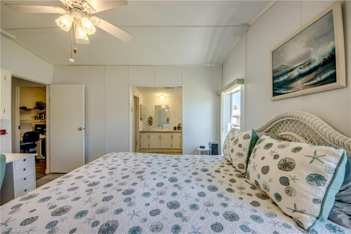 Bedroom featuring ceiling fan, ornamental molding, and ensuite bathroom
