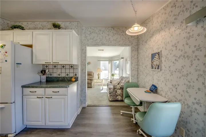 Kitchen featuring white cabinets, white refrigerator, and wood-type flooring
