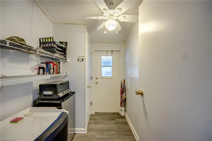 Clothes washing area featuring hardwood / wood-style floors, ceiling fan, and crown molding