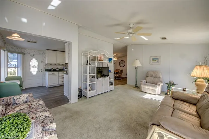 Living room featuring hardwood / wood-style floors, ceiling fan, and lofted ceiling