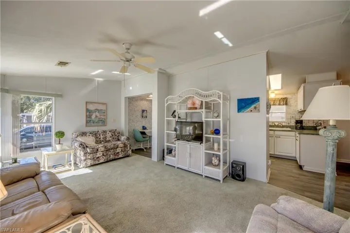Living room featuring light hardwood / wood-style flooring, ceiling fan, lofted ceiling, and sink