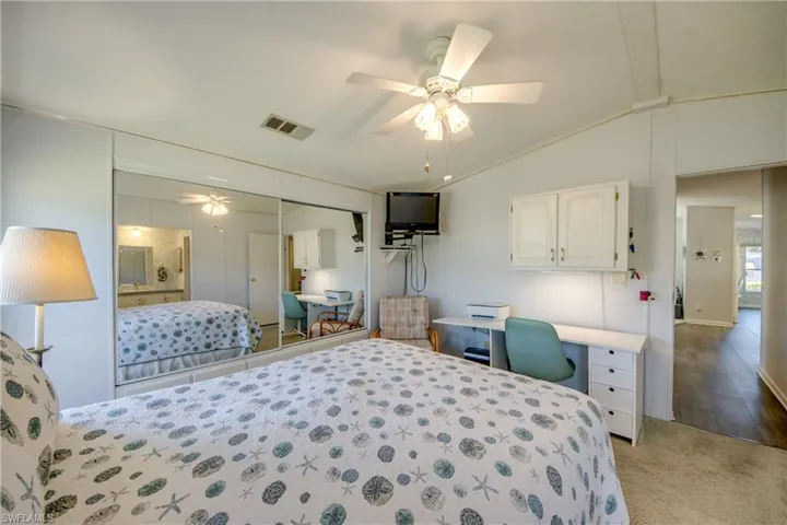 Bedroom featuring ceiling fan, light wood-type flooring, lofted ceiling, and a closet