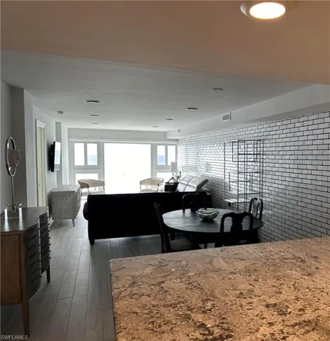 Dining room featuring dark hardwood / wood-style flooring and brick wall
