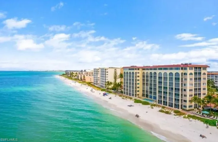 Birds eye view of property with a beach view and a water view