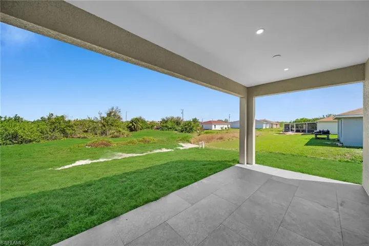 View of green lawn featuring a patio area