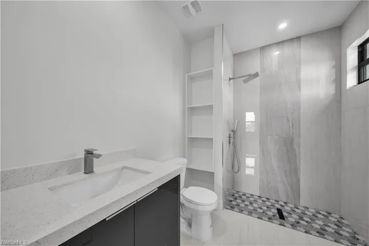Bathroom with vanity, a walk in shower, and recessed lighting