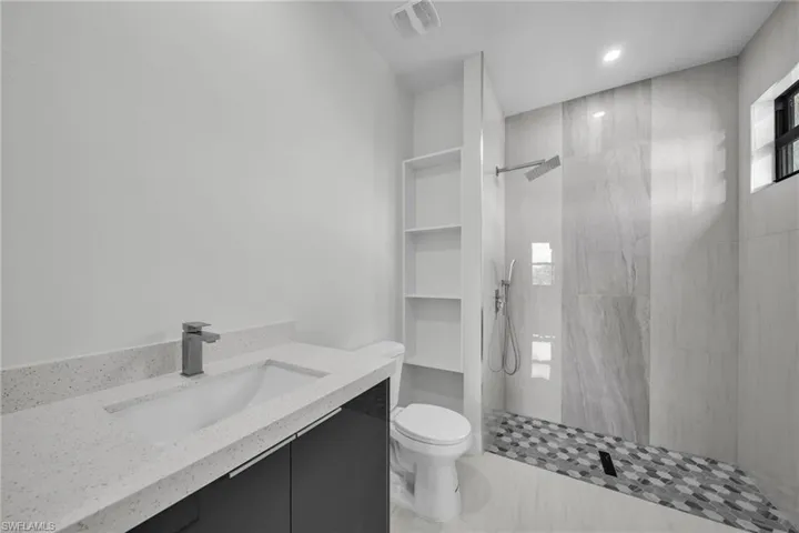 Bathroom with vanity, a walk in shower, and recessed lighting