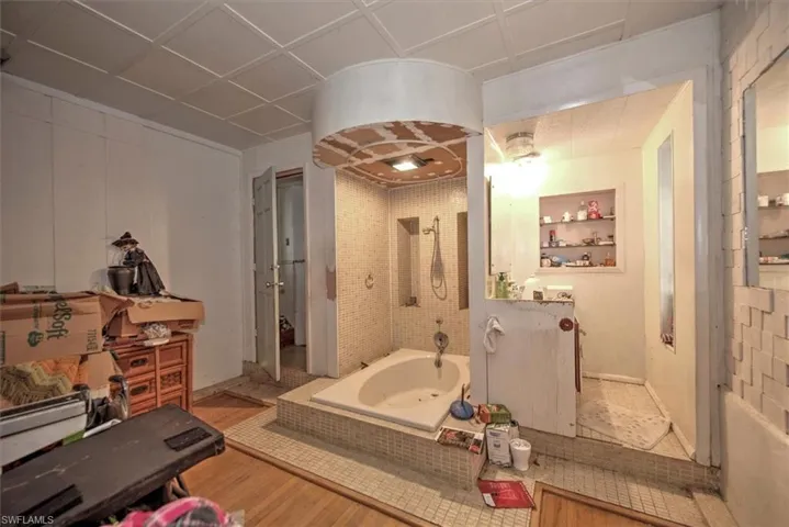 Bathroom featuring plus walk in shower, tile walls, a paneled ceiling, and tile patterned floors