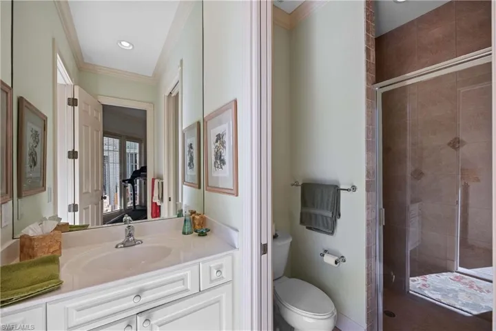 2nd Bedroom showing ensuite - Full Bathroom with vanity, ornamental molding, walk in shower, and toilet