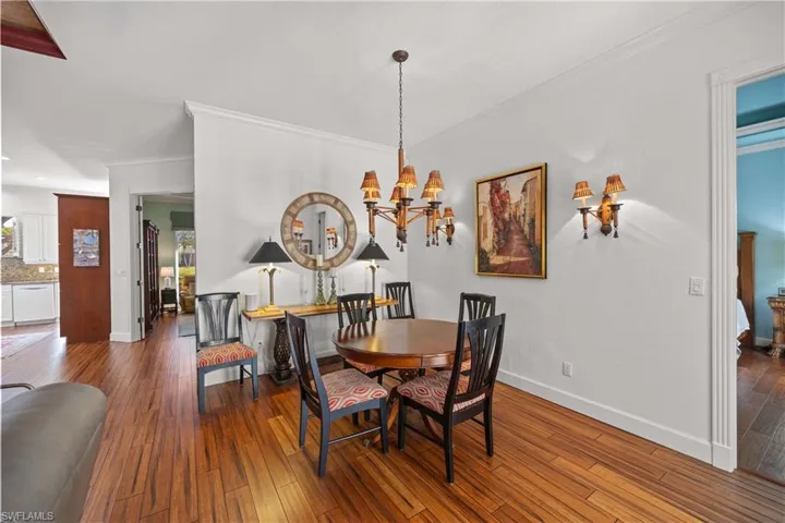 Dining area featuring an inviting chandelier, hardwood / wood-style floors, and ornamental molding