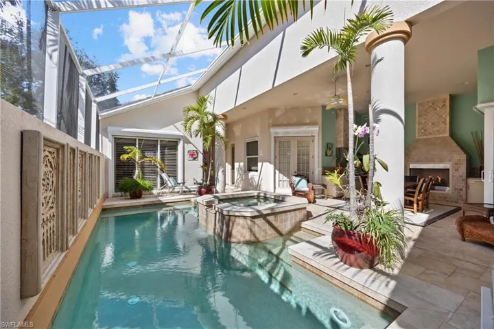 View of pool with an in ground hot tub, ceiling fan, exterior fireplace, and a patio area