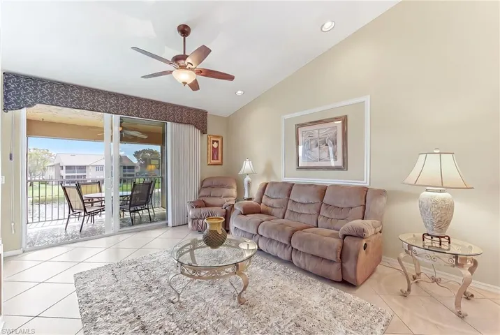 Living area with a ceiling fan, lofted ceiling, light tile patterned floors, and recessed lighting