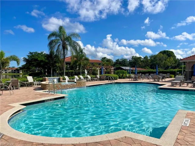 Community pool overlooking lake featuring a patio