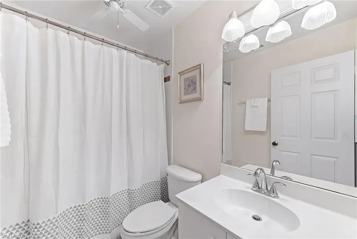 Full bathroom featuring vanity, a shower with shower curtain, and a ceiling fan