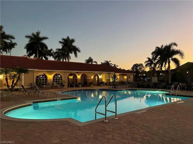 Pool at dusk featuring a community pool and a patio
