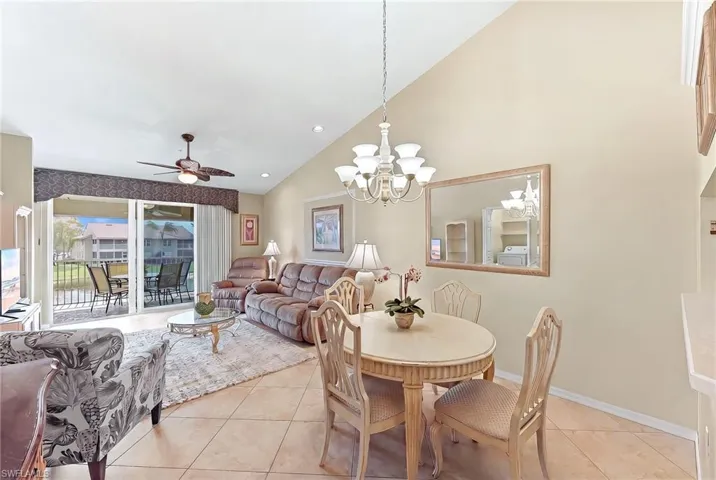 Dining space with ceiling fan, vaulted ceiling, light tile patterned floors, and hanging lights