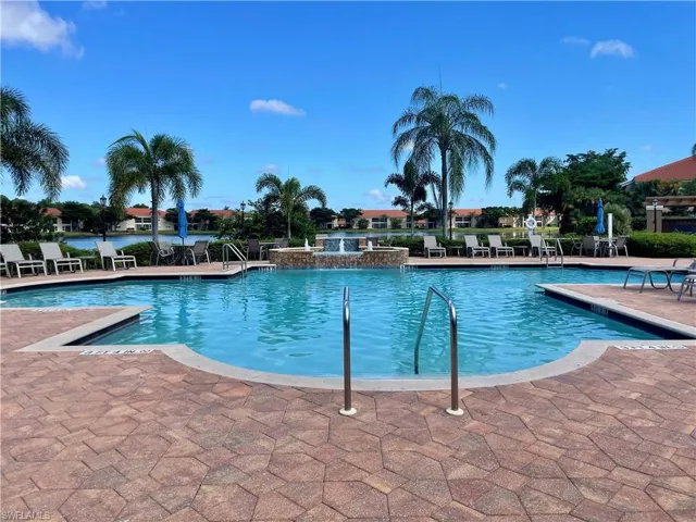 Community pool overlooking lake with a patio area