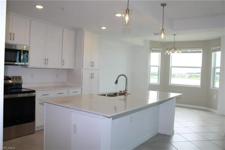 Kitchen featuring appliances with stainless steel finishes, a sink, recessed lighting, light tile patterned floors, and light countertops