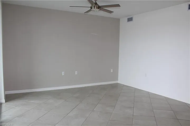 Unfurnished room with a ceiling fan, light tile patterned floors, and baseboards