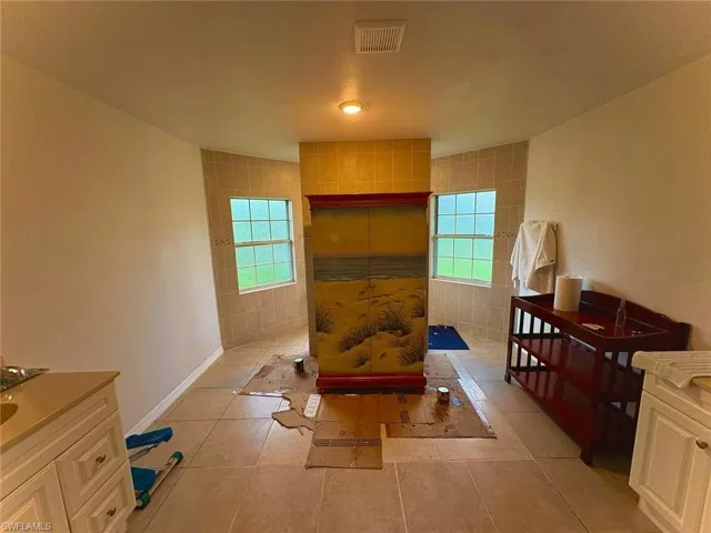 Bathroom with healthy amount of natural light, tile patterned floors, and walk in shower