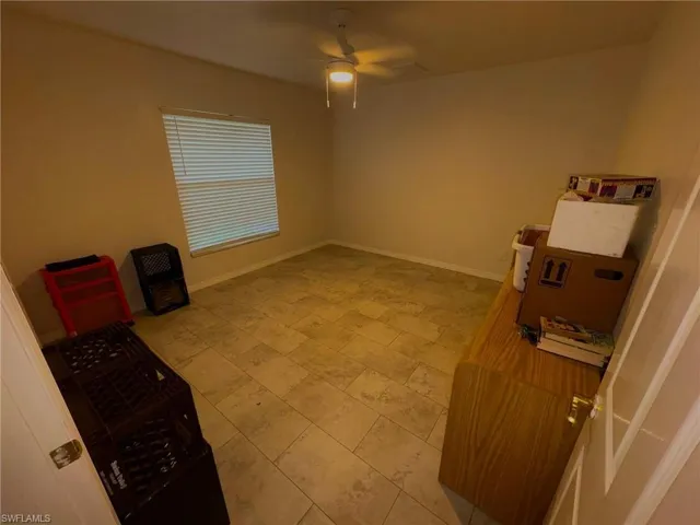 Spare room featuring ceiling fan and baseboards