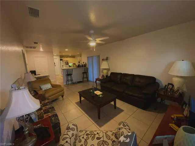 Living room with light tile patterned floors and ceiling fan