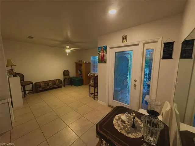 Foyer with a ceiling fan and light tile patterned flooring