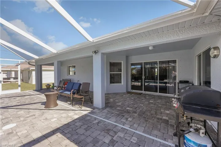View of patio with a grill and a lanai